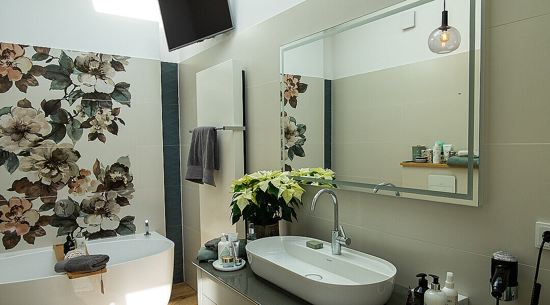 Modernisiertes Bad mit freistehender Badewanne, Aufsatzwaschbecken und beleuchtetem Spiegel in Leipzig-Meusdorf