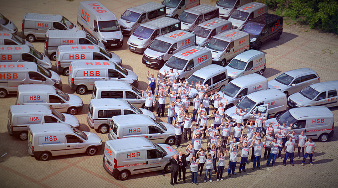 Mitarbeiter der HSB Unternehmensgruppe vor ihren Firmenfahrzeugen